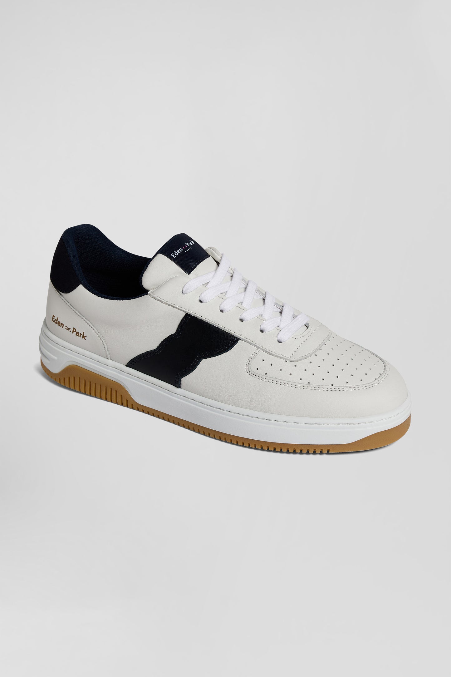 White low-top leather sneakers with navy blue cut-out